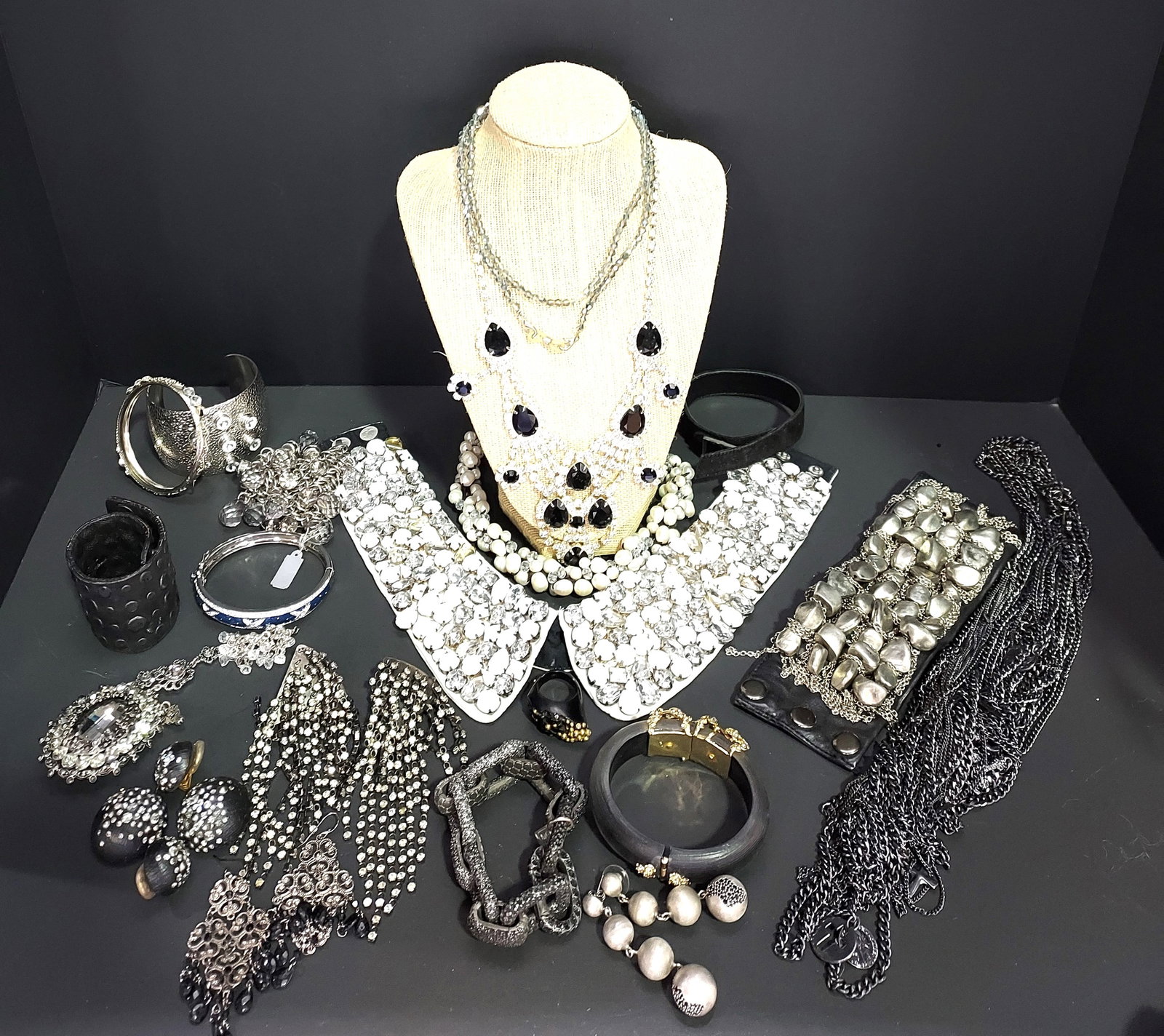H620 Signed and unsigned costume jewelry: Signed and unsigned costume jewelry: an unsigned leather cuff with silver tone nugget and chains; a Karl fabric collar necklace with clear rhinestones and white beads (missing stones); an unsigned sil