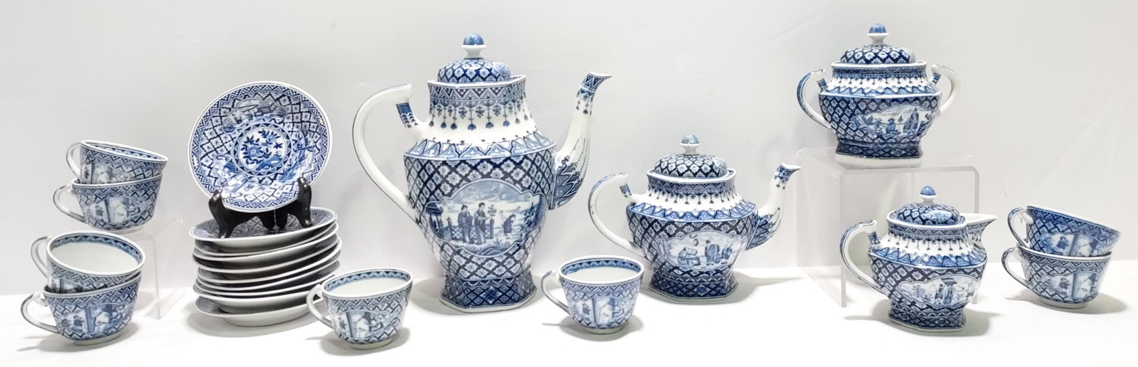 H194 A Japanese blue and white pottery tea set: An assembled Japanese blue and white pottery tea set in an English style including: Coffee pot, tea pot, 8 cups and saucers, sugar and creamer. 4th quarter 20th C.
