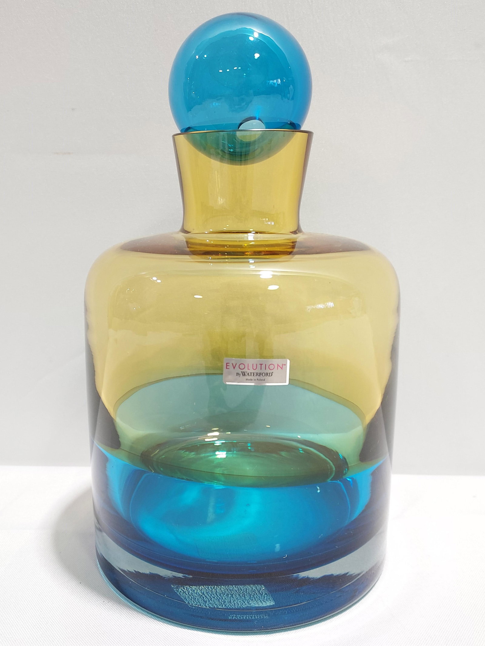 H141 Waterford "Evolutions" glass decanter: Waterford "Evolutions" turquoise and amber glass decanter with stopper, signed and with original label. 10.5" tall. Discontinued.
