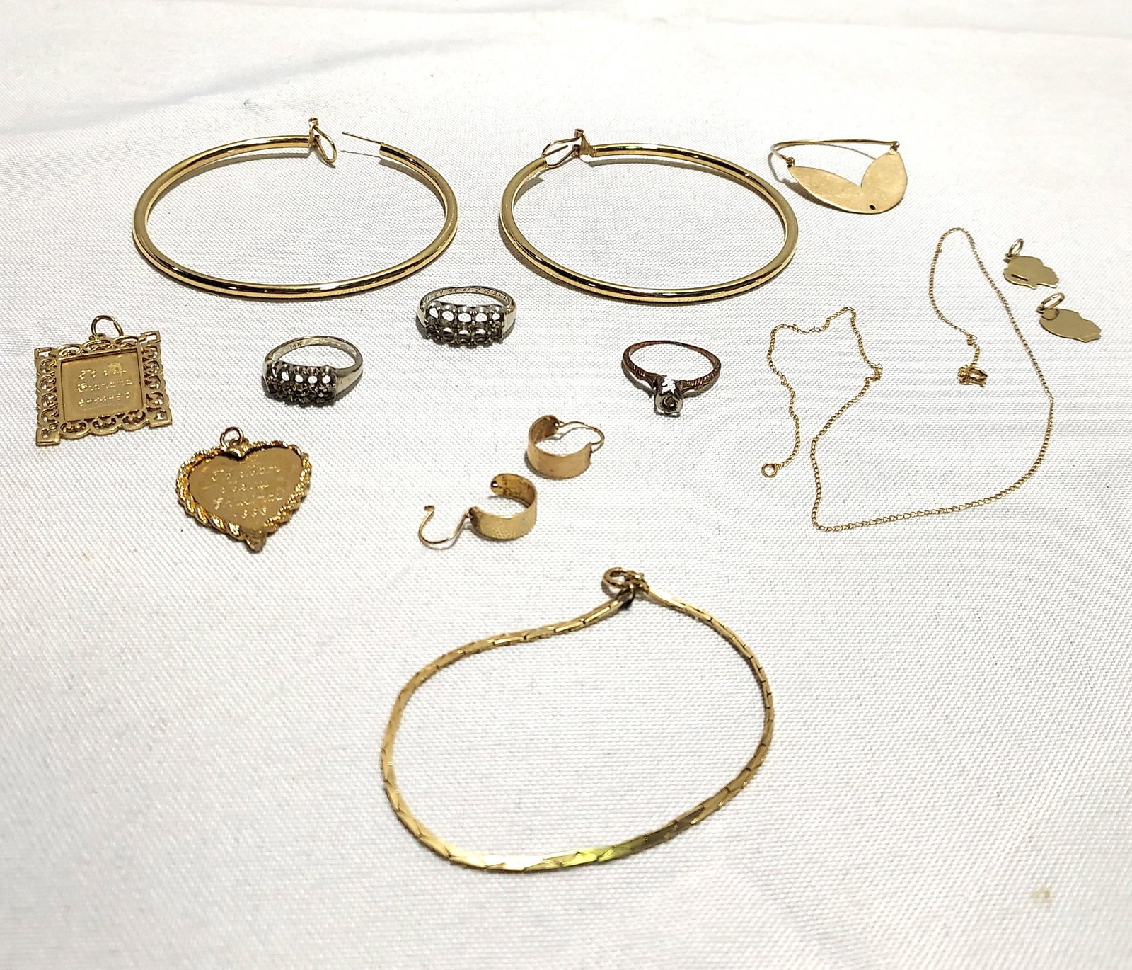H659 14 pcs - 29 grams total of unsigned 14k gold: 14 pcs - 29 grams total of unsigned 14k gold jewelry: a pair of large hoop earrings, an engraved heart shaped pendant, an engraved rectangular pendant, a fine fancy link bracelet, a white gold ring wi