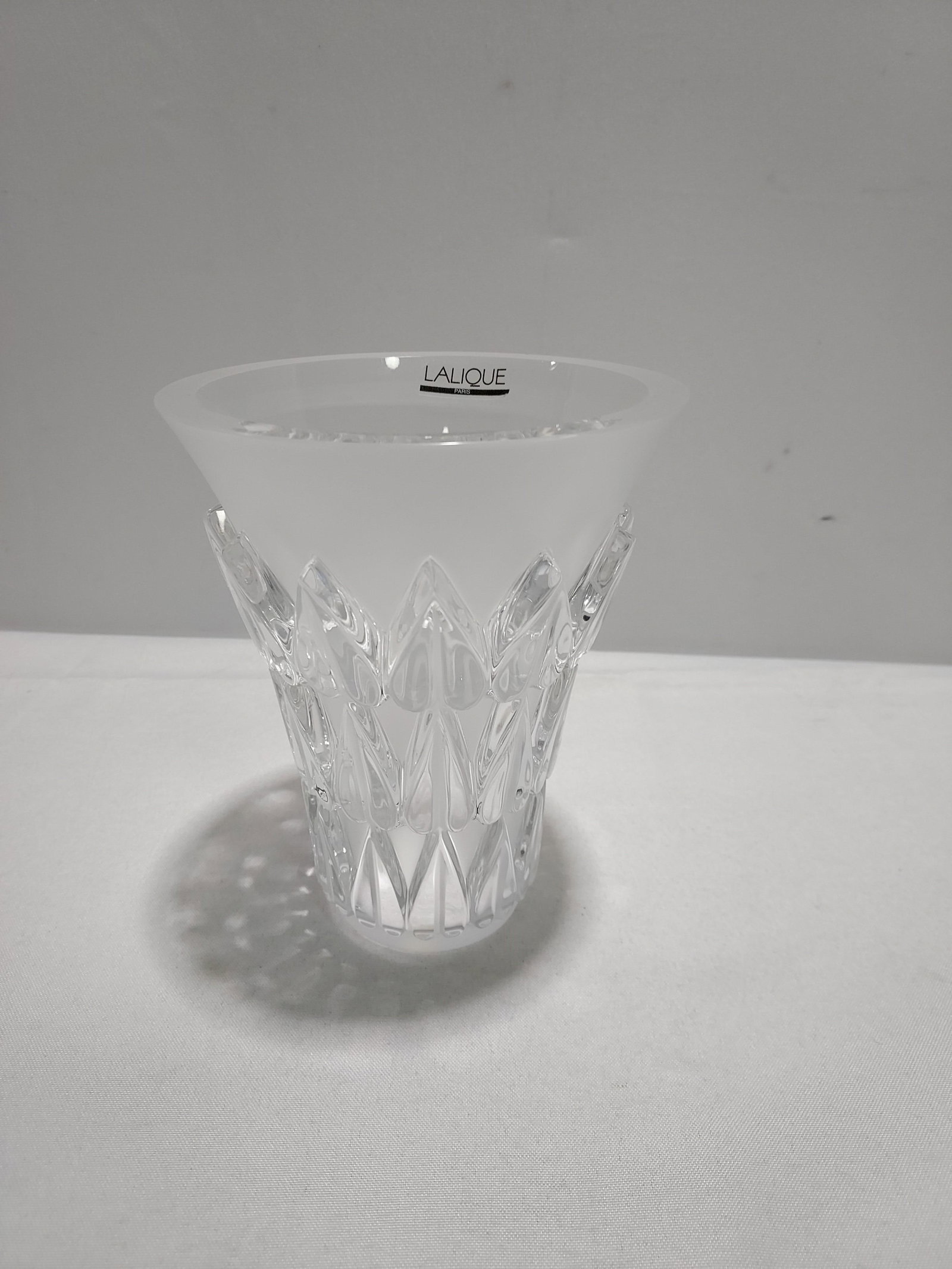 H915 Lalique Feuilles Vase.: Lalique Feuilles Vase. Trumpet form, clear and frosted crystal with three rows of leaves. 7" x 6".
