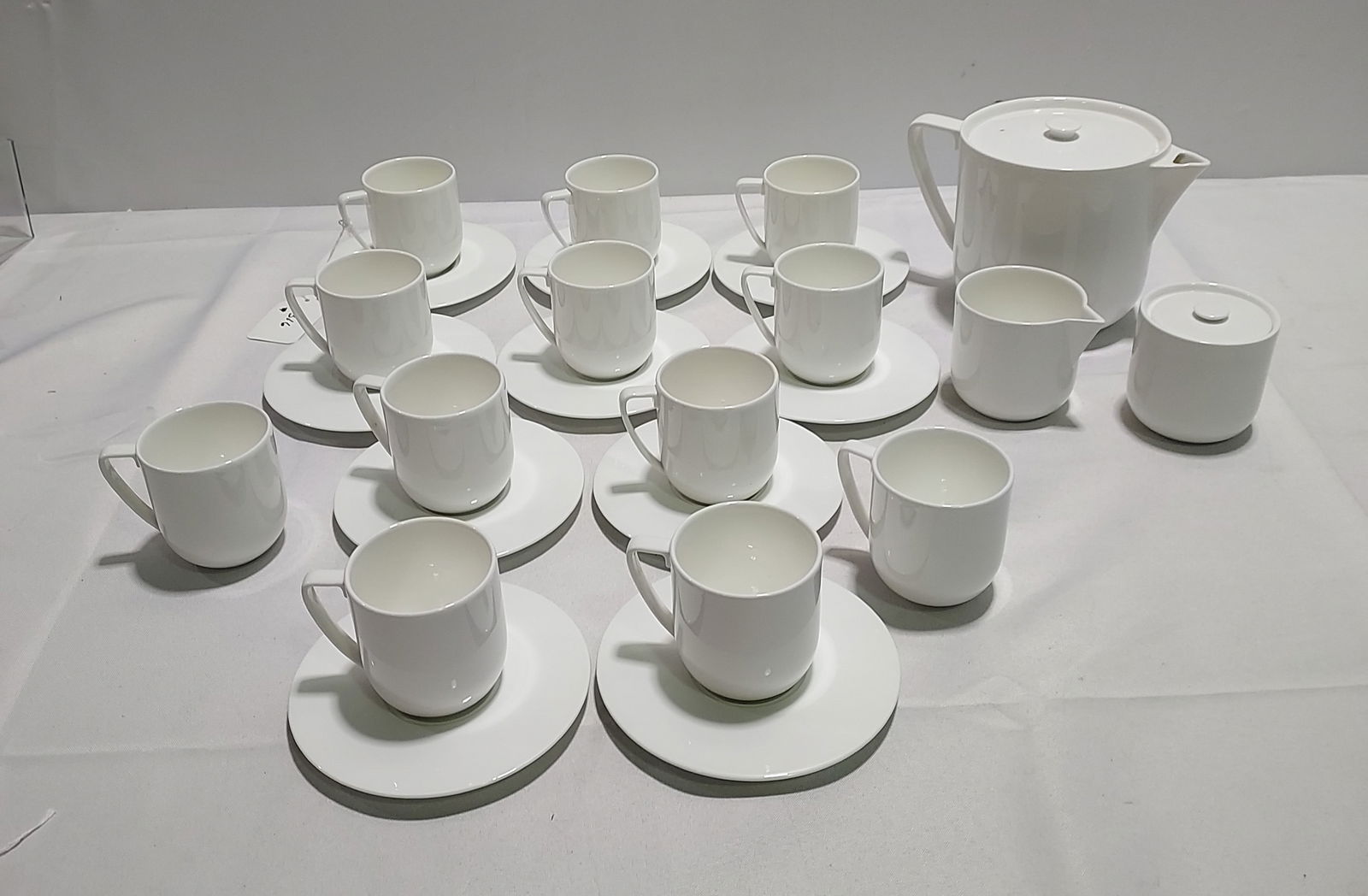 H1316 Vera Wang white porcelain dinnerware: Vera Wang white porcelain dinnerware pieces: "Saint Tropez". 1 tea pot, 1 creamer, 1 sugar, 12 tea cups, 8 small / 2 medium saucers.
