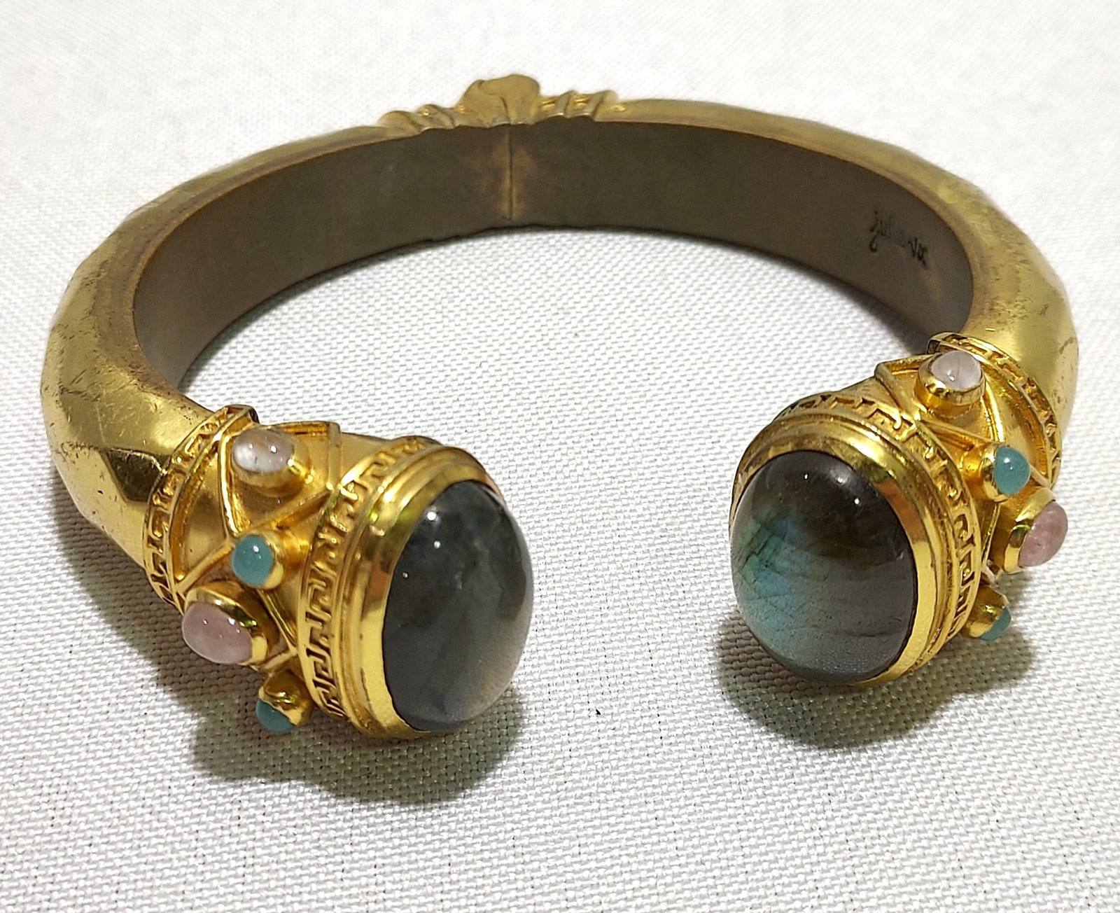 H643 Julie Vos gold toned cuff bracelet: Julie Vos gold toned cuff bracelet with gray moonstone, accents of pink and turquoise stones. Spring closure, inner dimensions: 2.25"x1.75". Good condition. Last quarter 20th c.
