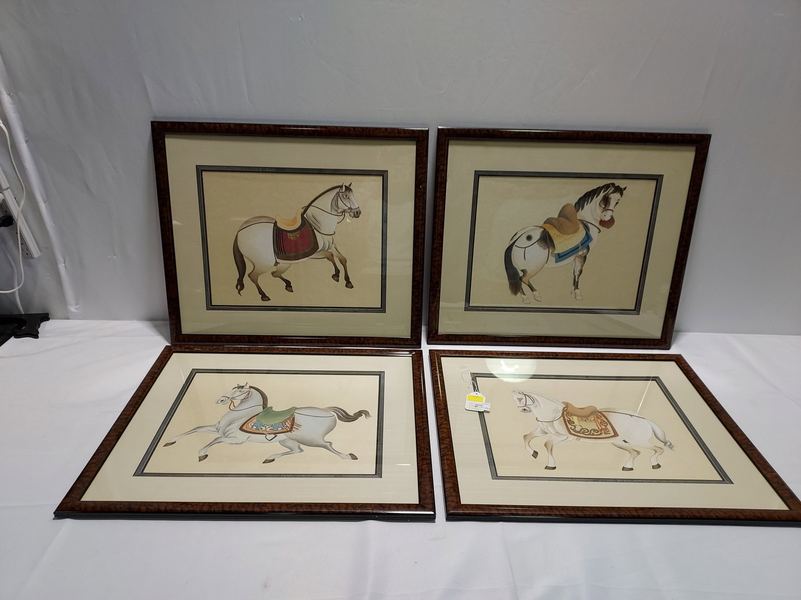 H1622 Four CHINESE PAINTINGS ON SILK: Four Chinese paintings of silk depicting horses. Both matted, under glass, and framed in wood frames with a faux burl finish. 26" x 22" x 1"