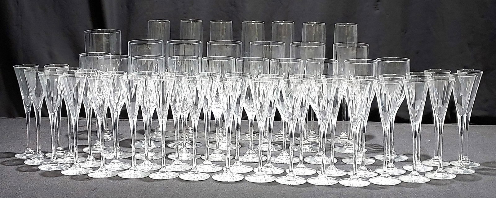 H1350 Orrefors Optica Symphony Wine Stems 77pc: 77 Orrefors Optica Symphony wine stems: 7 champagne flutes 10", 33 cordial stems 7", 10 white wine stems 7.25", 26 red wine 8.25", and 1 water goblet 10". (we've found numerous boxes, some added to lo