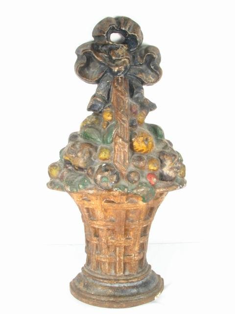 CAST IRON "BASKET OF FLOWERS" DOORSTOP: Cast iron doorstop in the form of a basket of flowers. Unmarked, and with remains of paint still showing. Condition: wear to paint and finish, signs of age, see images. Measures 15.3" tall x 7.8" wide