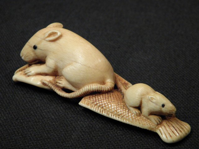 JAPANESE CARVED IVORY NETSUKE: RATS ON FISH: Japanese carved ivory netsuke depicting two rats on a dead fish. Inlaid at the eyes, with intricately detailed rat coats. Unsigned. Condition: minor discoloration as expected with age, small age crack