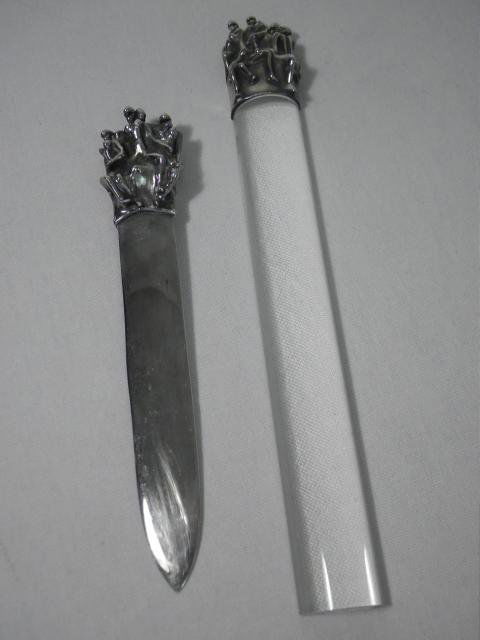 JEAN FILHOS FOR CHRISTOFLE: LETTER OPENER & MAGNIFIER: Two desk accessories by Jean Filhos for Christofle, each depicting a group of stylized nude figures. The two-piece lot includes: A silver plate over bronze letter opener or page turner with engraved a