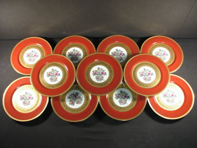 ELEVEN L. BERNARDAUD LIMOGES SERVICE PLATES: Lot of eleven 10.5" porcelain service plates by L. Bernardaud & Co, Limoges, France. Each plate is decorated with a center floral surrounded by gilded and iron red/orange borders. All plates are marke