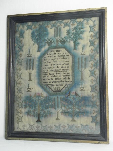 EARLY AMERICAN NEEDLEPOINT SAMPLER: ANN KEYLOCK, 1823: An early American cross stitch needlepoint sampler. Features a verse surrounded with floral decorations, signed and dated underneath "Ann Keylock, 1823". Condition: needlepoint colors have run with ag