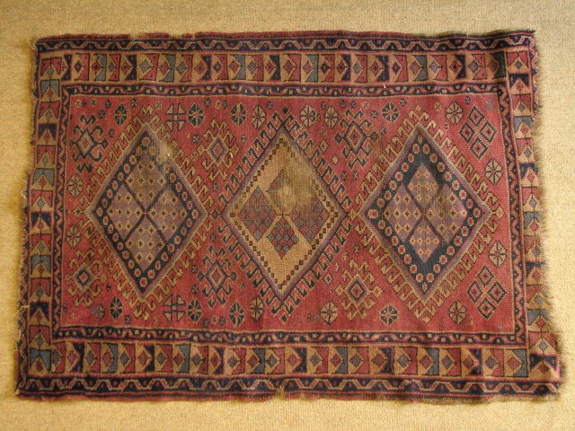 SMALL CAUCASIAN HAND KNOTTED RUG - 47" X 33": Small Caucasian hand knotted area rug. Measures 47" x 33" wide, with a geometric pattern in colors of purple, black, blue, off white, etc. Condition: heavy wear to pile in center, minor fraying at edg