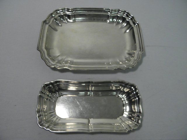 TWO STERLING SILVER STEPPED RIM TRAYS 28 TROY: Lot of two sterling silver trays, both with stepped rims. The first is made by Gorham and measures 10" long x 5.1" wide, and the second is unmarked as to maker, and measures 11.75" long x 8.6" wide. B