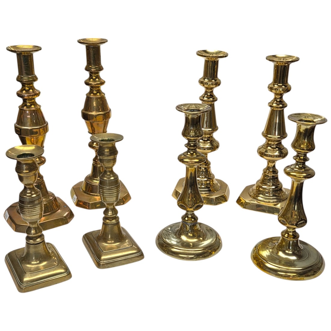 4 SETS (OF TWO) BRASS CANDLESTICKS: A collection of four vintage brass candlestick sets (of two), each featuring an adjustable push-up mechanism. These candlesticks showcase a classic design with varying base shapes, including square an