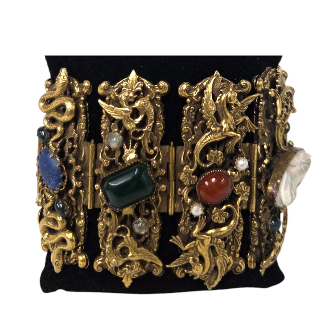 EGYPTION REVIVAL BRACELET ATTRB. TO NEIGER BROS: Egyption revival inspired vintage bracelet featuring 8 filigree panels. Each panel consists of mythical characters including dragons, Pegasus, snakes, and Griffins and adorned with a shell cameo, lapi