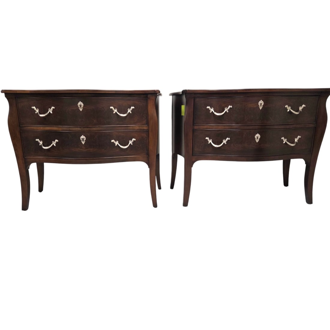 2 COUNCILL SERPANTINE CHESTS OF DRAWERS: Two Councill chests. Each with a dark walnut finish, two drawers, and decorative silvered hardware. Each measures 34.5" x 45"W x 21"D. Water damage on one side of the top one chest. See images