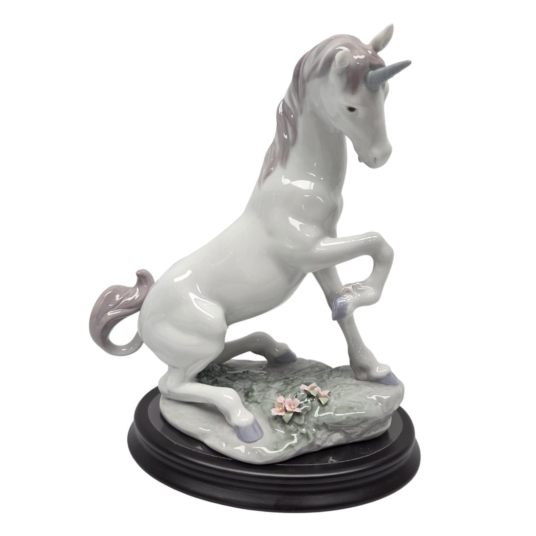 LLADRO MAGICAL UNICORN PORCELAIN FIGURINE: LLadro "Magical Unicorn" porcelain figurine of unicorn on with small pink flowers #7697. Measuring 8.5"H x 8"W x 4"D. Stamp on bottom. Excellent condition.