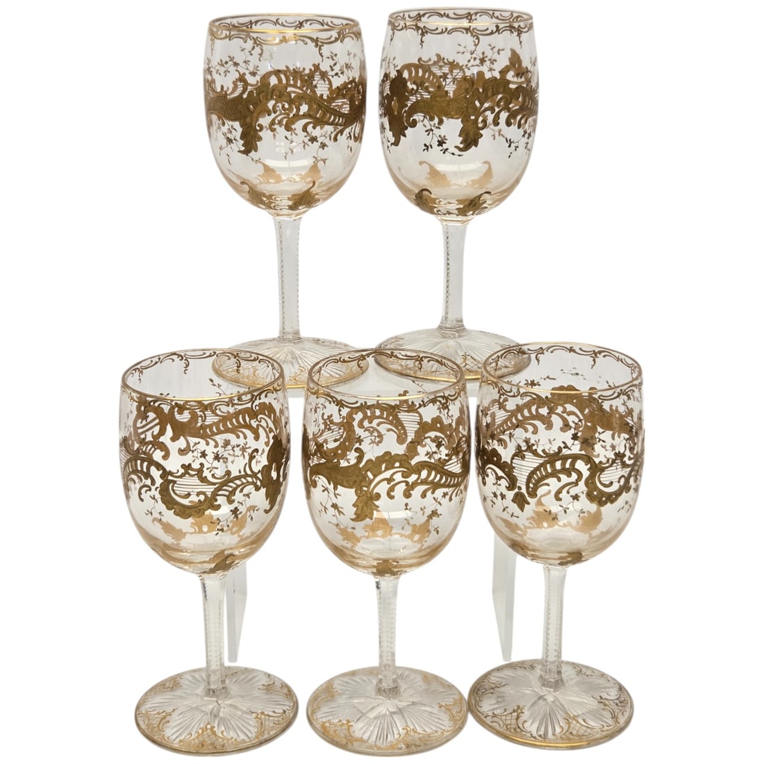 5 PC ST LOUIS CRYSTAL GILT PORT WINE GLASSES: A set of five St Louis crystal port wine glasses, each adorned with intricate gold gilding. These glasses stand 4.75" tall with a diameter of 2", and collectively weigh 0.7 pounds. The decorative gold