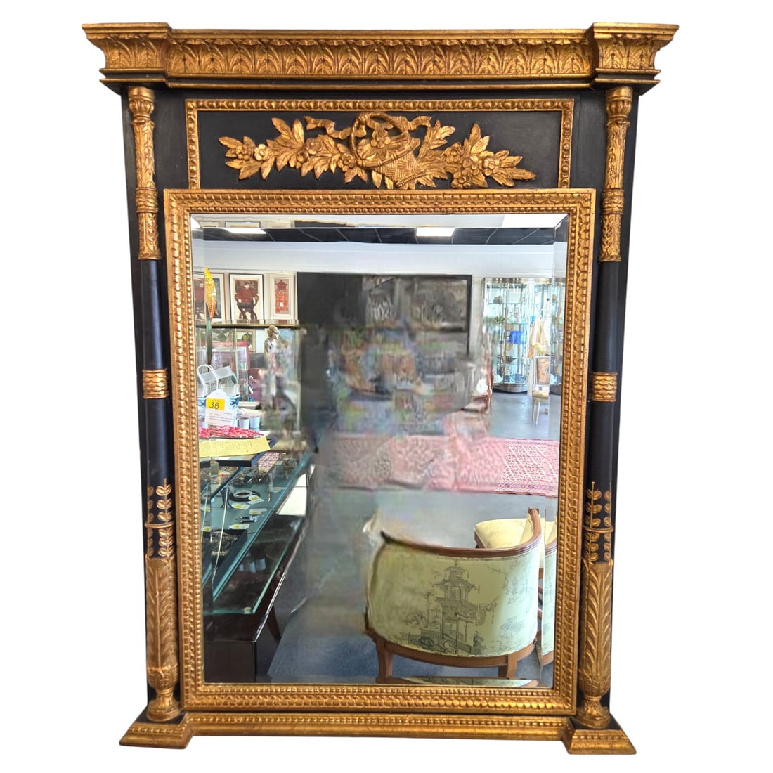 LARGE BLACK / GOLD HOLLYWOOD REGENCY MIRROR: A large Hollywood Regency style black and gold framed wall mirror. 52"H x 39.5"W x 3"D. SHIPPING NOTE: Live Auctioneers offers a very convenient shipping option. For a second opinion, these are the sh