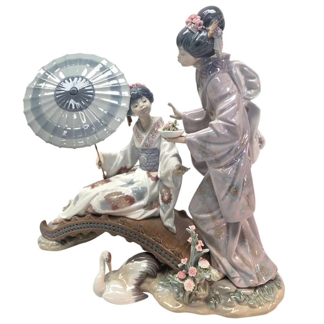 LLADRO "SPRINGTIME IN JAPAN" PORCELAIN FIGURINE: Lladro "Springtime in Japan" porcelain figurine. Retired in 2019. Measures 12"H x 14"W x 7" D. Stamp on bottom. *Chip on rim of umbrella. See photos. SHIPPING NOTE: Live Auctioneers offers a very