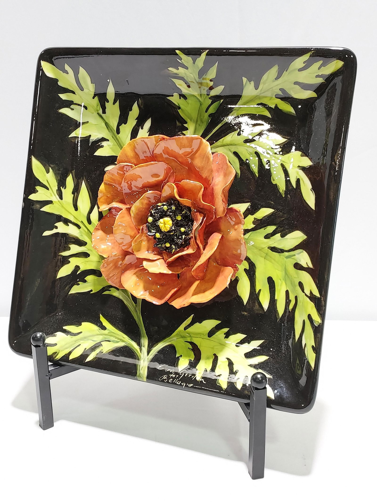 EVA GORDON HANDPAINTED CERAMIC FLOWER PLAQUE: Eva Gordon hand painted ceramic flower wall plaque measuring 13.5"H x 13.5"W x 1.75"D. Signed lower right "Eva Gordon for Bellagio". Condition: good, no losses or repairs, see images. SHIPPING NOTE: L