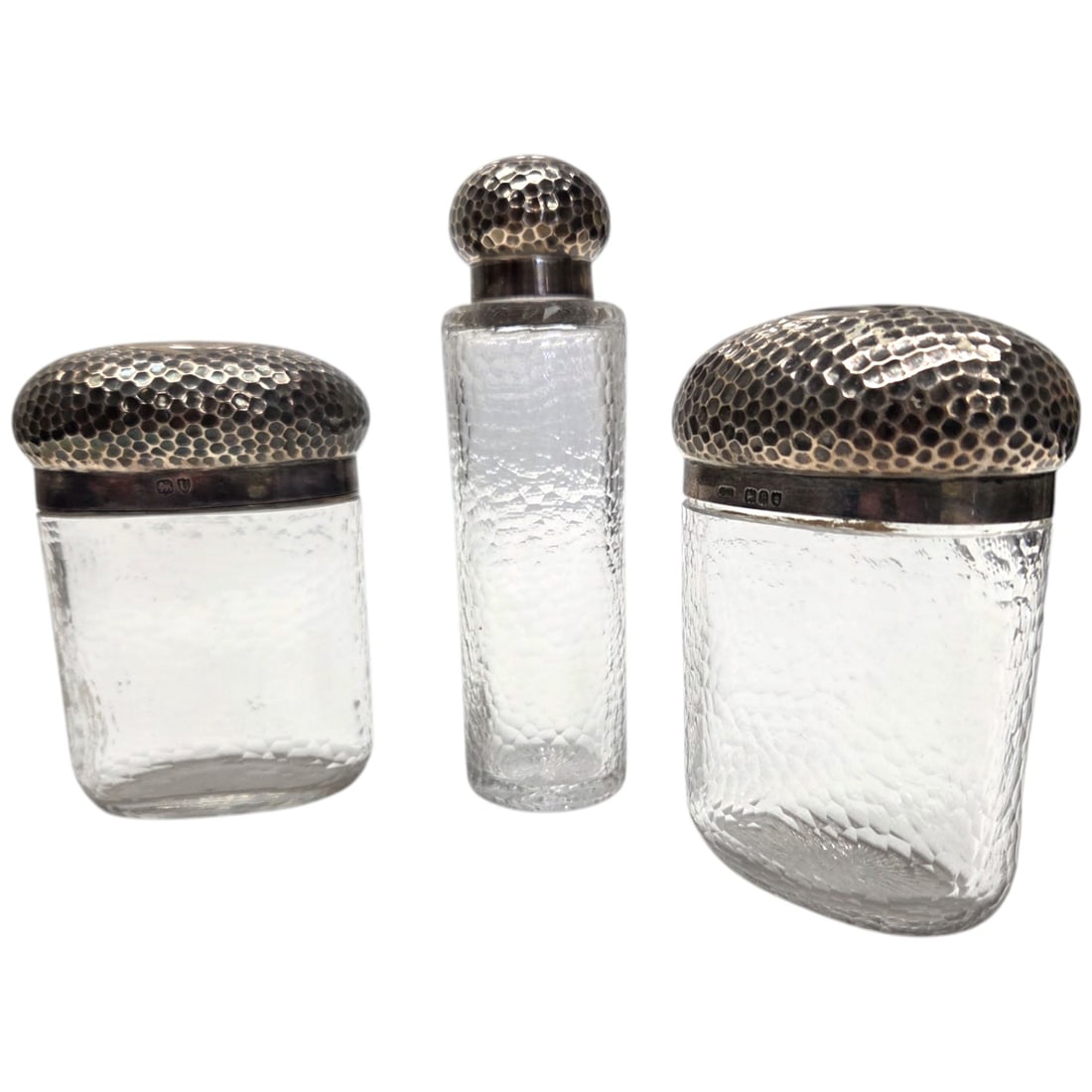 3PC LARGE STERLING LIDDED VANITY JARS: Three large London England sterling lidded vanity jars. Likely originally men's, but a great size for ladies too. Each with a hammered texture design on lids and glass. One lift-top gold washed lid in