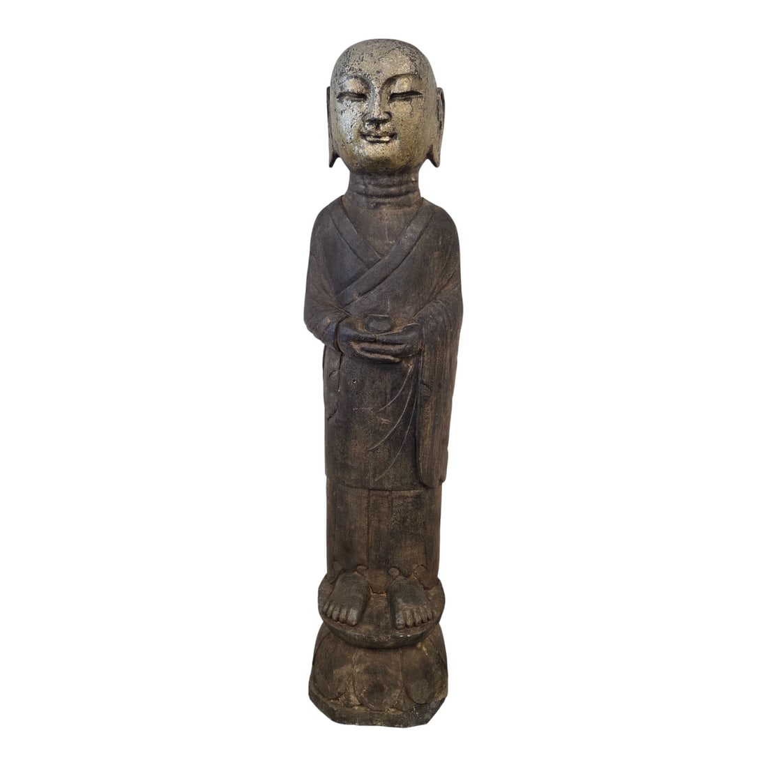 CARVED STONE STANDING LOHAN GARDEN SCULPTURE: A well-carved stone sculpture of a standing Buddha. Distressed and weathered gold leaf to face and head, flat back, serene expression, folded hands encircling a round object. Stands 38.5" tall x 10"
