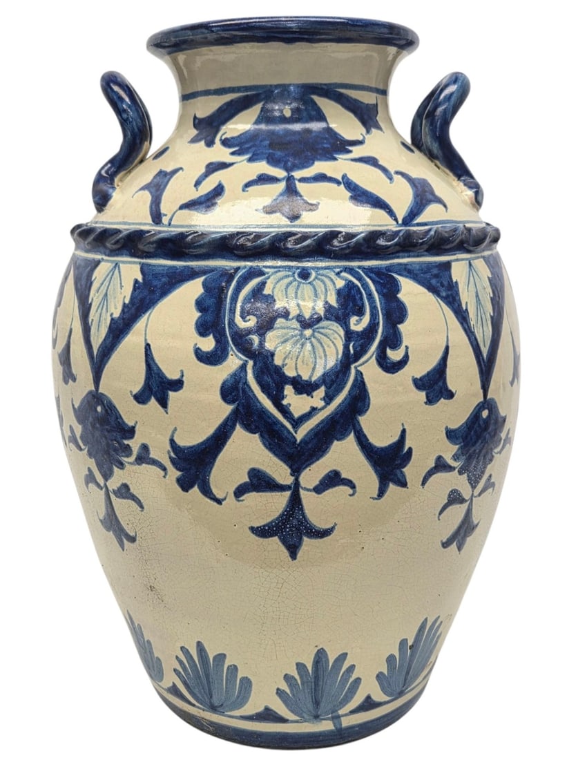 HAND PAINTED TALAVERA BLUE/WHT VASE W/HANDLES: One large blue and white decorative hand painted Talavera vase with decorative twisted ribbon like detail just below the handles. Measures 20"H x 13"W . Signed by artist Vazquez on bottom. Slight chip