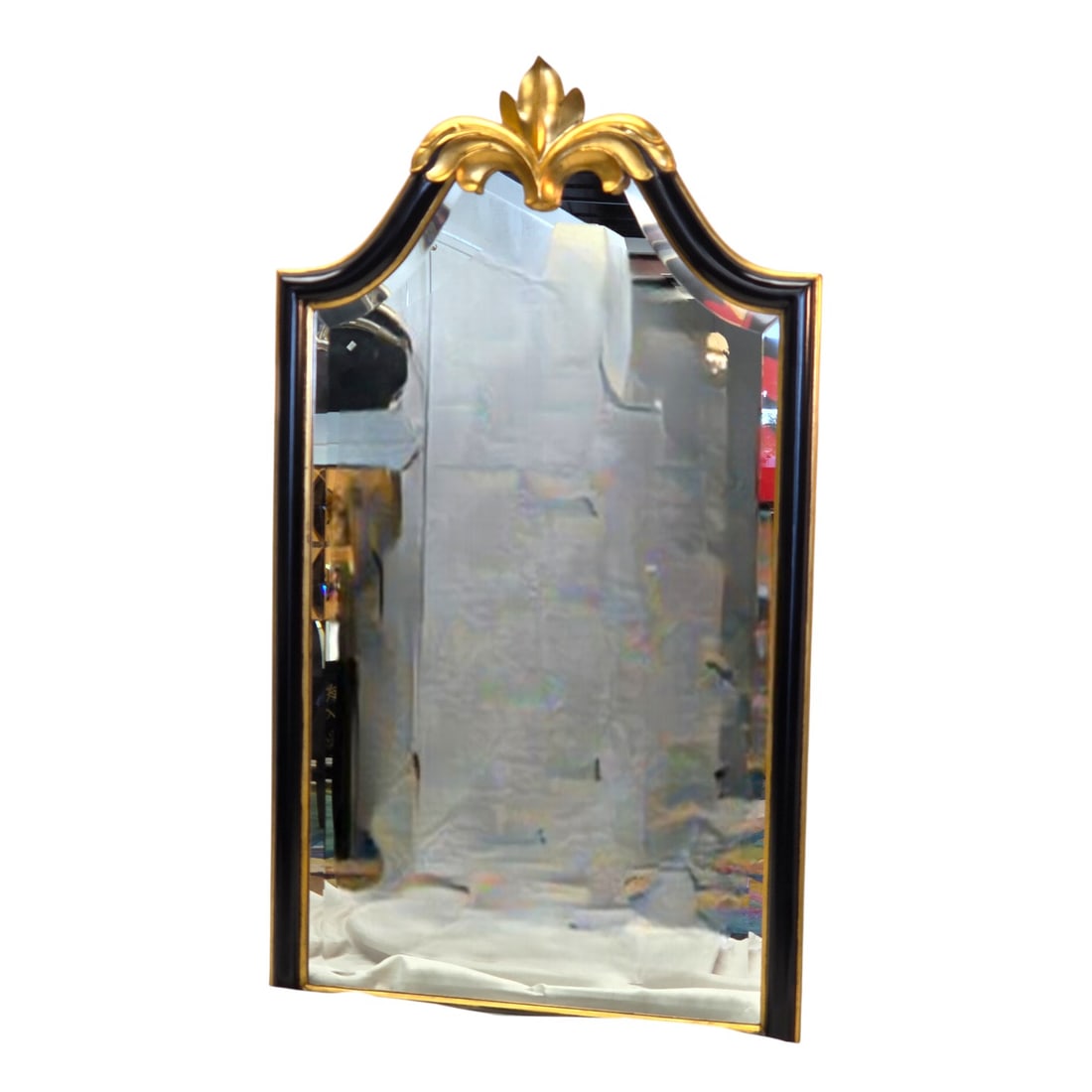 HARRISON & GIL HOLLYWOOD REGENCY MIRROR: Harrison and Gil black and gold gilt beveled wall mirror. Features a decorative top crest with an acanthus leaf motif. Original sticker on back. See photos. Measures 48" H x 27"W. Good condition.