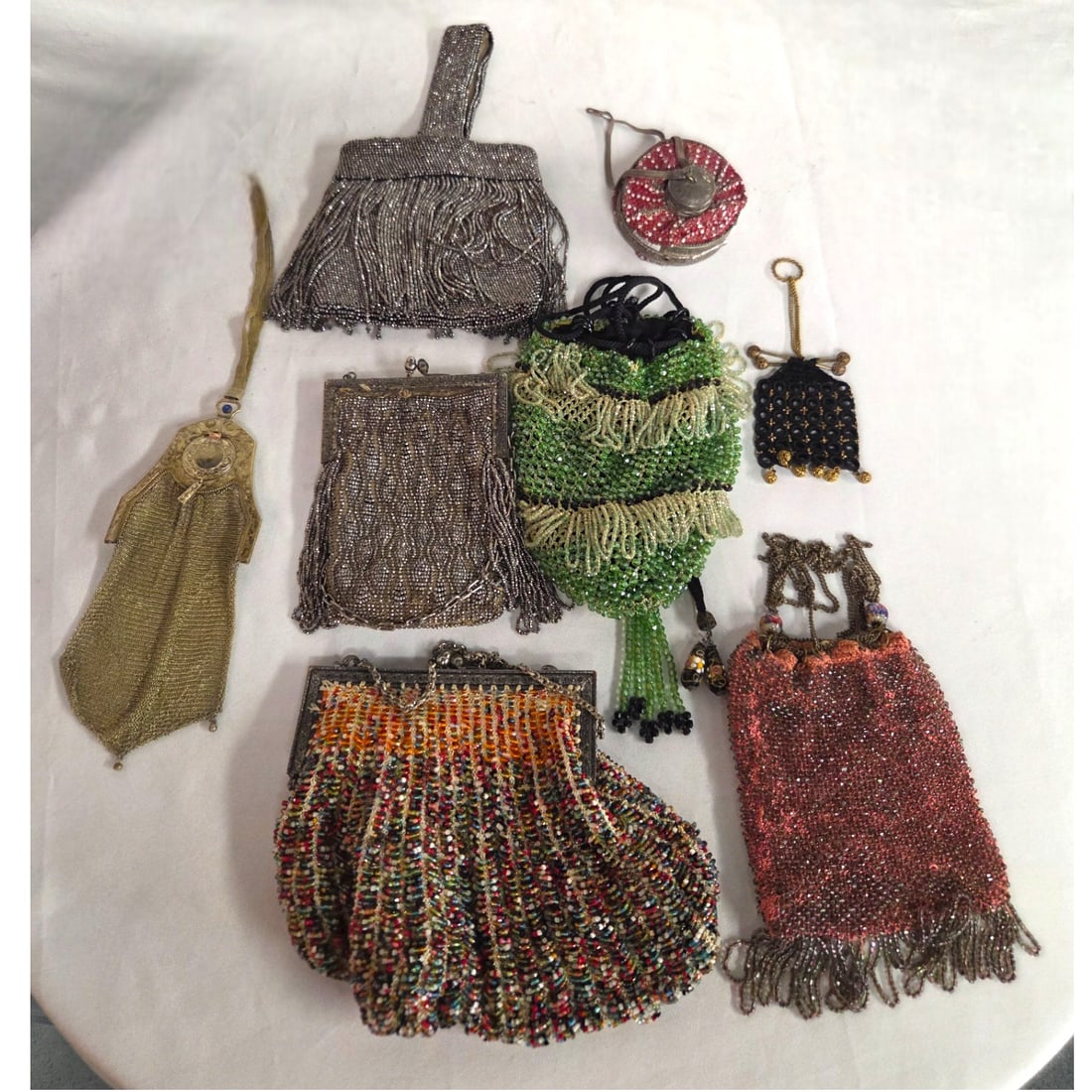 7 VINTAGE BAGS WHITING DAVIS DELYSIA, BEADED ETC: Seven collectible vintage purses. 1) A French hematite beaded purse with long fringe and beige cloth interior, Small area of rust. 5" x 5.5" wide. 2) a vintage framed hematite beaded bag with chain ha