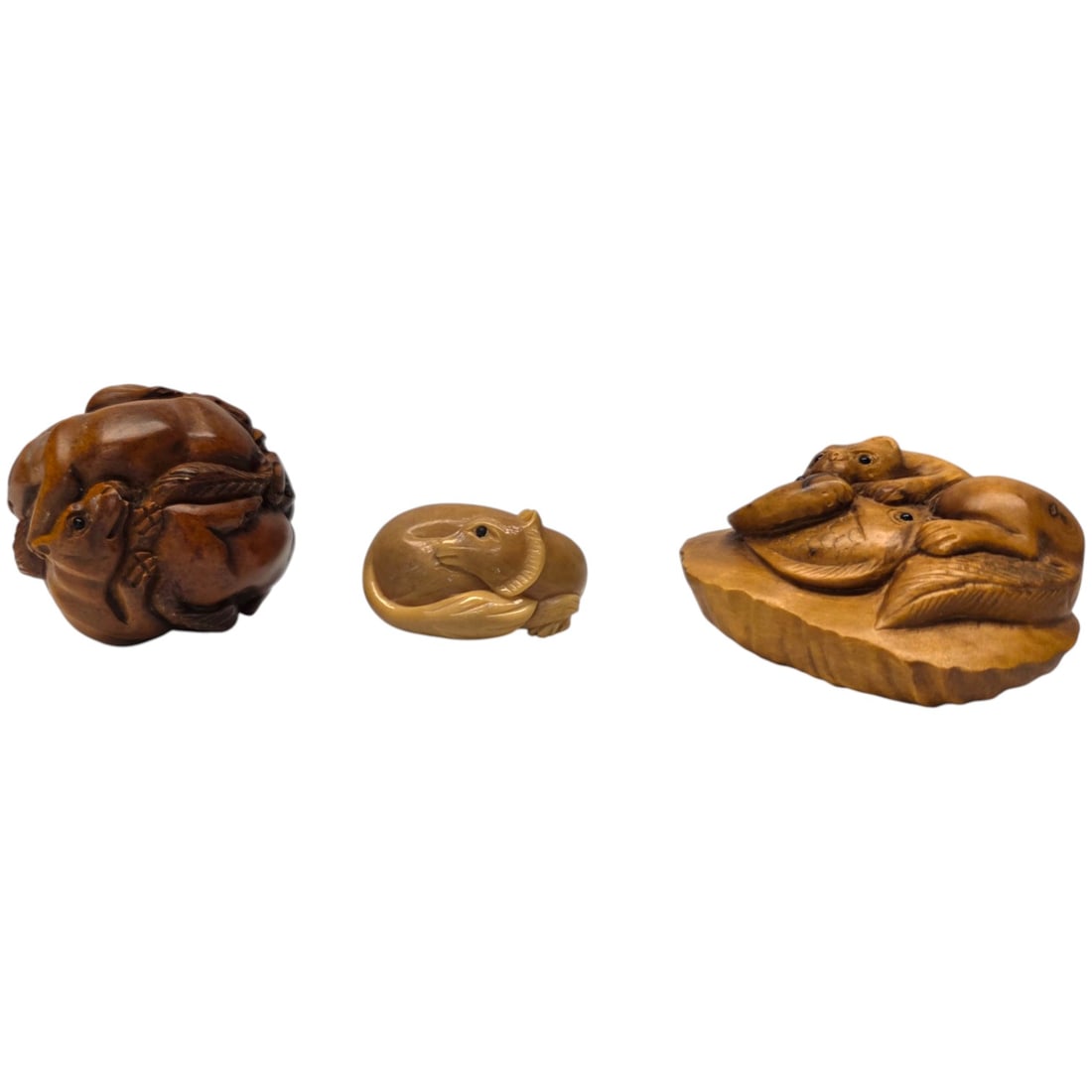 3pc - 2 JAPANESE CARVED OKIMONO & A CARVED NETSUKE: The boxwood netsuke is in the form of a large round ball with numerous carvings of entwined foxes. The Okimono carving is on a blond wood, possibly olive wood depicting a fox with two fish. The unders