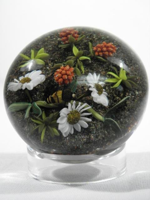 PAUL STANKARD BOTANICAL & BEE LAMPWORK PAPERWEIGHT: Paul Stankard botanical lampwork paperweight depicting daisies and raspberries with a bumblebee. The underside depicts roots in the form of four nude figures. Small signature cane on base bears the St