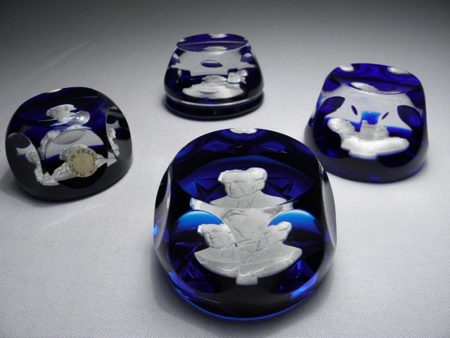 FOUR CRISTAL D'ALBRET CARVED SULPHIDE CAMEO PAPERWEIGHT: Lot of four Cristal D'Albret carved sulphide cameo paperweights. Ground colors include (2) royal blue, (1) blue, and (1) cobalt. Thomas Jefferson weight is marked on base "The Franklin Mint Cr-Albret 