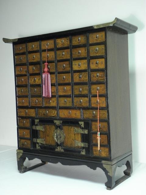 LATE 19TH C KOREAN METAL MOUNTED APOTHECARY CHEST: Late 19th or early 20th century Korean metal mounted apothecary chest with a pagoda style curved top. A total of forty-six small drawers, with a larger two door locking compartment near the bottom (do