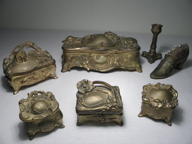 SEVEN ASSORTED ART NOUVEAU GILT METAL BOXES: Lot of seven assorted Art Nouveau period gilt metal boxes, etc. Includes a large jewelry casket, two small trinket boxes (one by Jennings Brothers), two medium sized boxes, a candlestick, and a pin cu