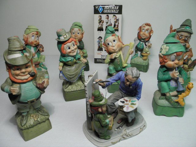TEN COLLECTIBLE MUSICAL PORCELAIN LEPRECHAUN DECANTERS: Lot of ten collectible porcelain leprechaun decanters by Hoffman Distilling Co. One is still in original packaging, and one is from a separate series, depicting a man painting a picture of a leprechau