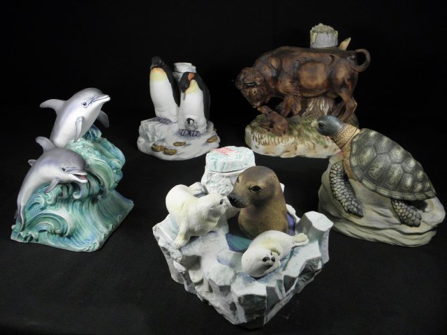 FIVE HAND PAINTED PORCELAIN WILDLIFE LIQUOR DECANTERS: Lot of five Cyprus Noble hand painted porcelain wildlife bourbon decanters. Includes a Buffalo with calf, Dolphins, Sea Turtle, Penguins, and Seal with pups. Condition: good, no chips or cracks, possi