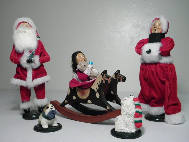 FIVE BYERS CHOICE CAROLER FIGURES: Lot of five Byer's choice caroler figures. Includes Santa Claus and Mrs. Claus, a woman in a rocking chair, and two small dog figures. Condition: generally good, see images. Largest measures 13" tall.