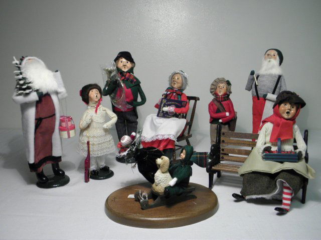 EIGHT BYERS CHOICE CAROLERS: SANTA, ETC.: Lot of eight Byers choice caroler figures. Includes Santa Claus, Mrs. Claus, plus accessories such as the wood and cast iron park bench, etc. Condition: sledder has come off of wooden base, overall ge