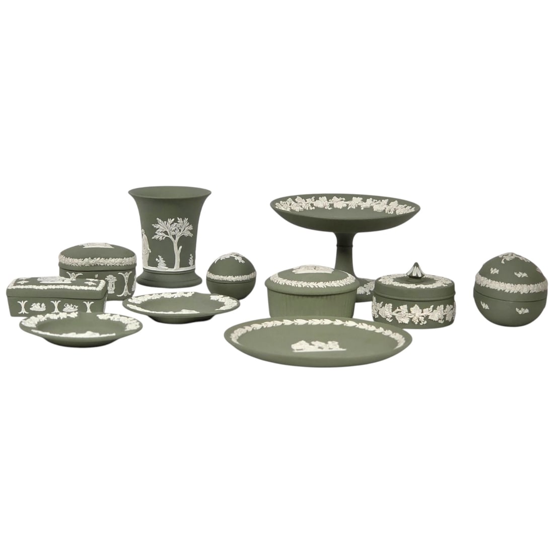 11 PC SAGE GREEN WEDGWOOD JASPERWARE: A collection of eleven pieces of sage green Wedgwood Jasperware. Lot consists of lidded trinket boxes in various sizes, heart shaped box, square box, bud vase, candlesticks, and more. All decorated wi