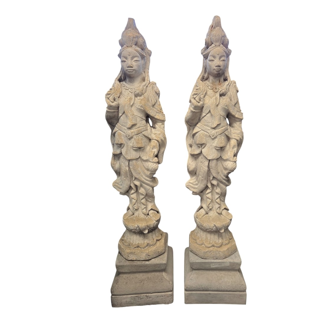 PR OF CAST STONE FEMALE DEITY GARDEN STATUES: Pair of cast stone (or concrete) garden statues. Each depicting a standing female deity wearing a tiered elaborate crown, necklaces,and long flowing robe standing on lotus pod base. They measure 42 H 