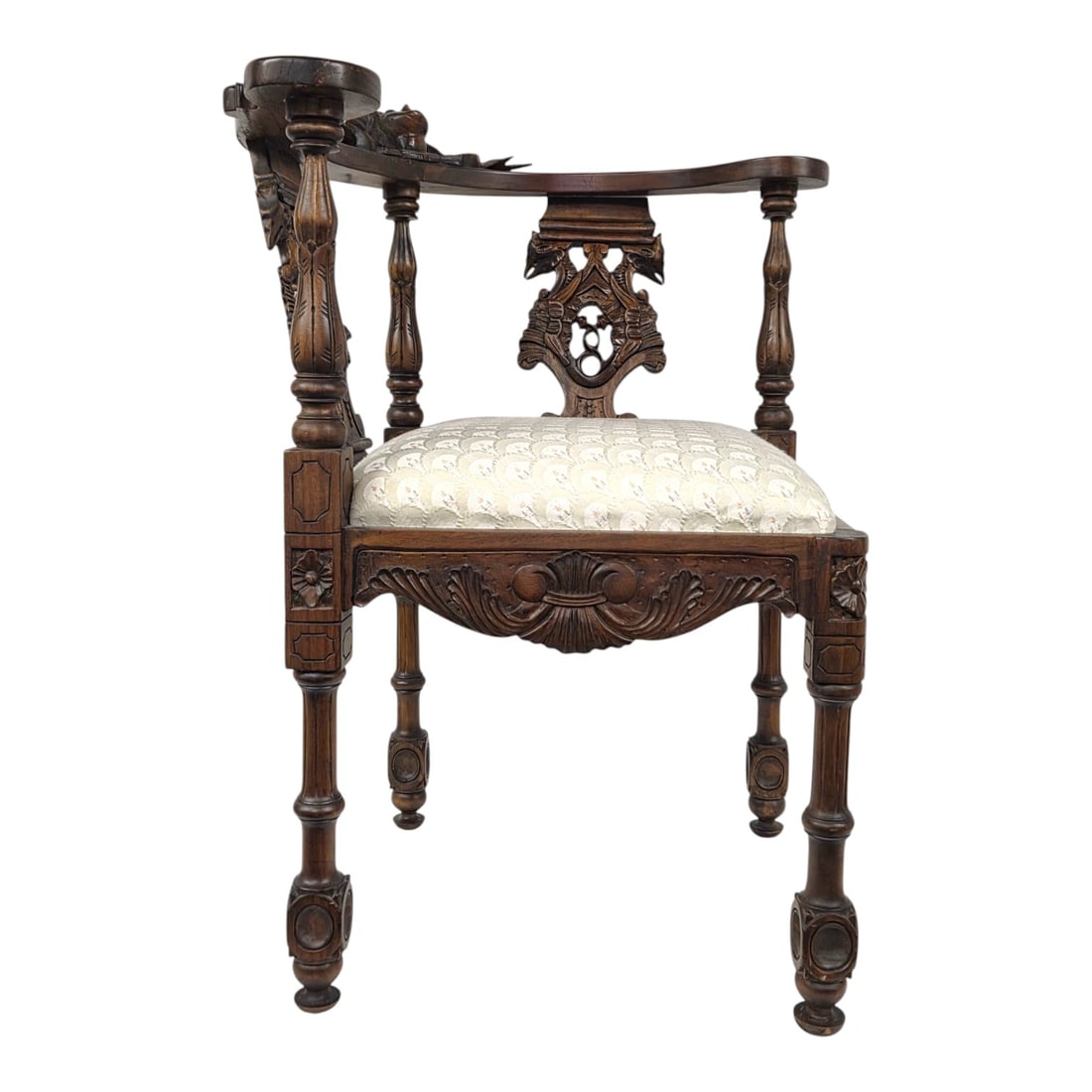 ITALIAN RENAISSANCE REVIVAL CORNER CHAIR: Italian Renaissance revival corner chair featuring figural reliefs of a cherub head, acanthus leaves, and scroll work. Upholstered seat has some discolorations. see photos. Measures 31 H x 29 W x 27 D