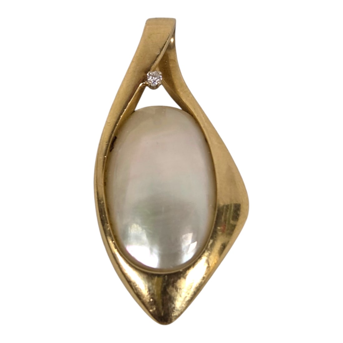 MODERNIST-STYLE 14 KT GOLD POLISHED SHELL PENDANT: A modernist-style pendant with a large oval polished shell and small prong-set round diamond in a substantial 14kt yellow gold bezel. Pendant measures 2 x 1 x 1/8 . The visible pearl measures approx. 