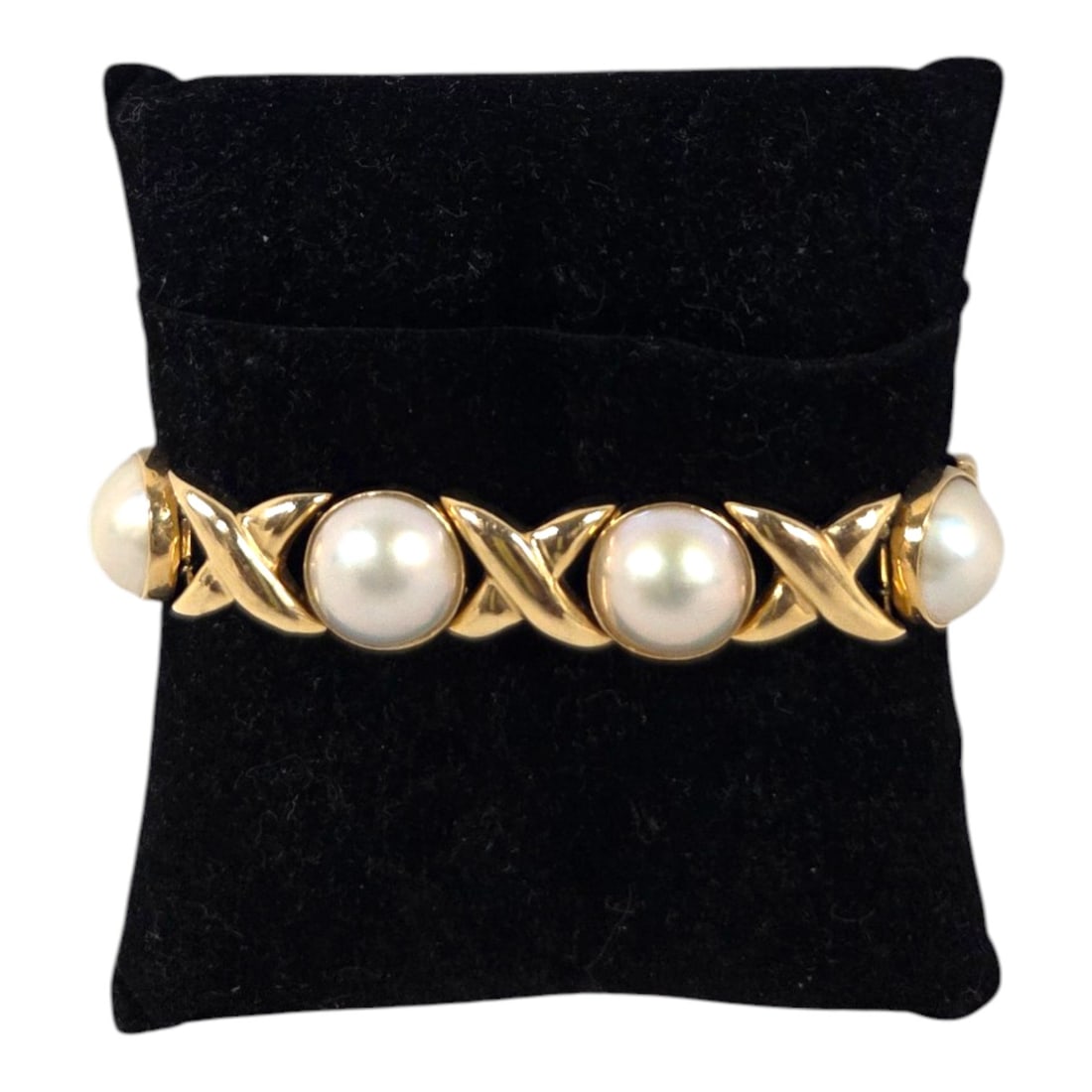 QUALITY MABE PEARL & 14 KT "X" LINK BRACELET: A finely crafted 14 kt yellow gold bracelet with seven round mabe pearls spaced with seven 14 kt gold x frame links and a closed box clasp with safety. Stamped 14kt RZ . Measures 6 3/4 . Total Weight 