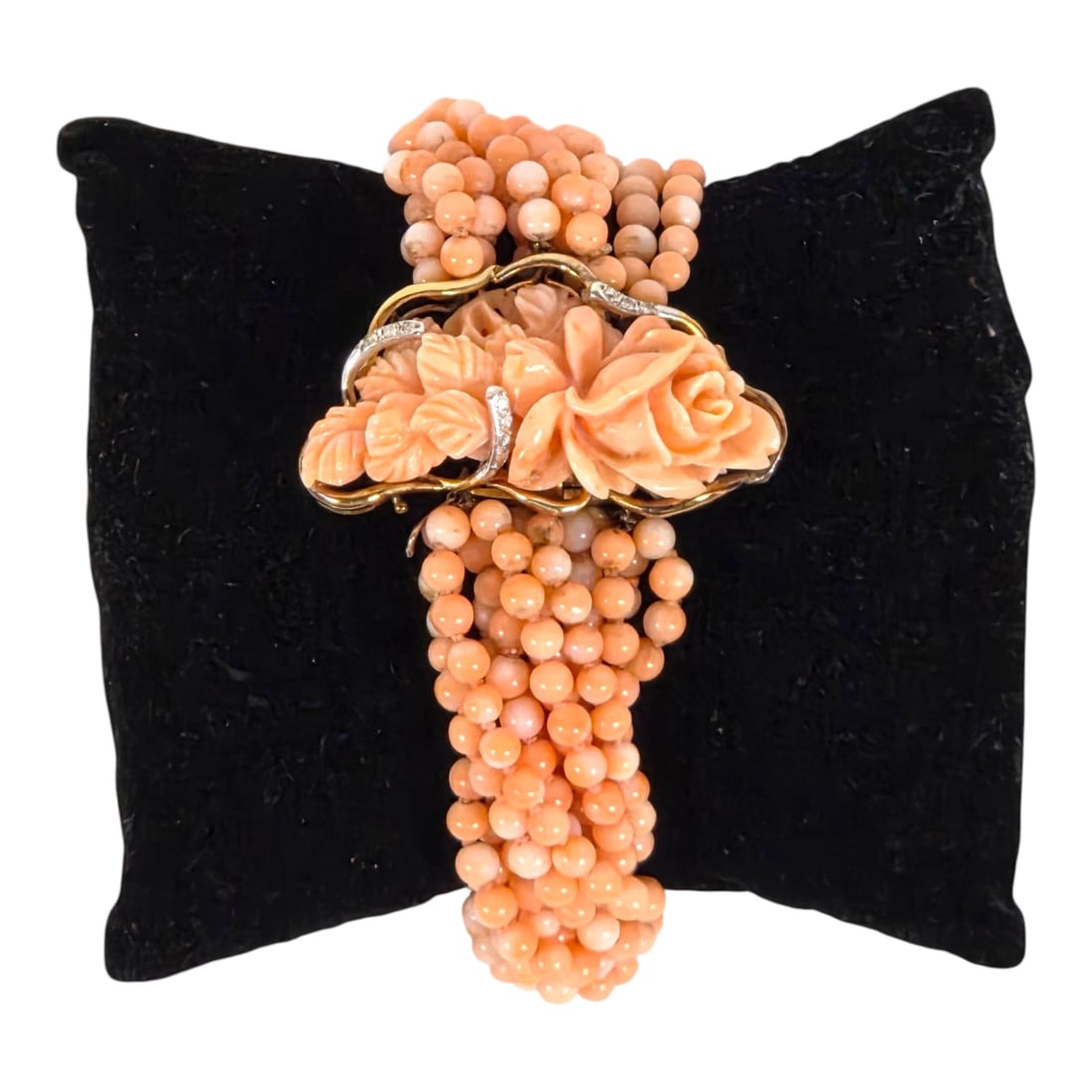 CARVED CORAL, DIAMOND, 14KT GOLD BRACELET: Beautiful twelve strand pale coral bead bracelet with carved rose floral center design. (1 3/4 x 1 ) enclosed by three 14kt gold branches each set with 3 small diamonds and having protective open