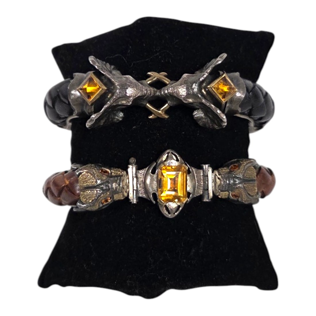 TWO GOTHIC STYLE LEATHER STERLING 18KT GOLD CUFF BRACELETS: Two cuff bracelets. Each of sterling silver with inset braided leather, animal heads, inset stones and 18 ct gold applied details, both are hinged with safety clasps, stamped 925 and 18 ct. The double