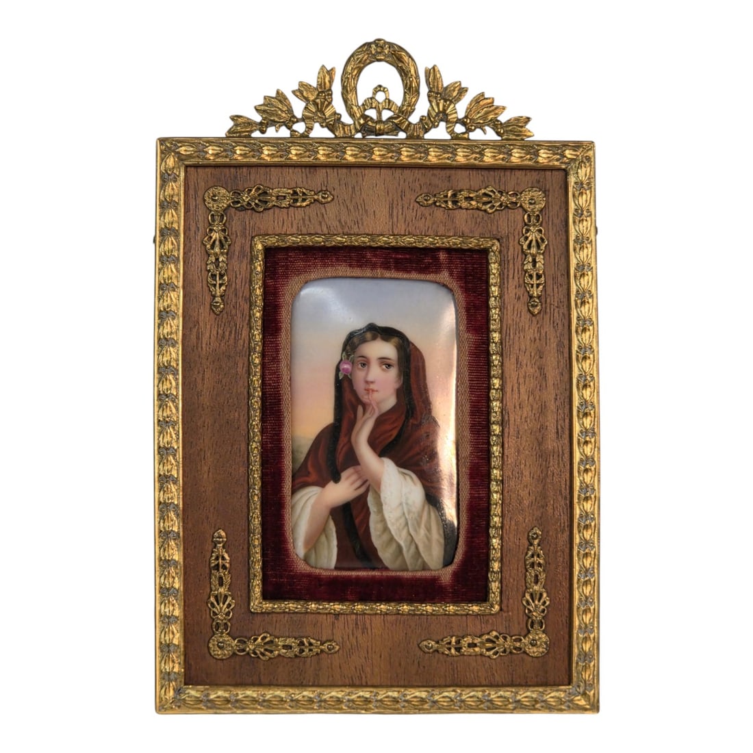 MINIATURE PAINTING ON PORCELAIN WOMAN WITH ROSE: Hand-painted portrait of a robed woman with a rose in her hair gesturing to keep a secret. Gilt bronze frame has a red velvet matting ( some wear to the velvet), and intricate metal ornamentation at