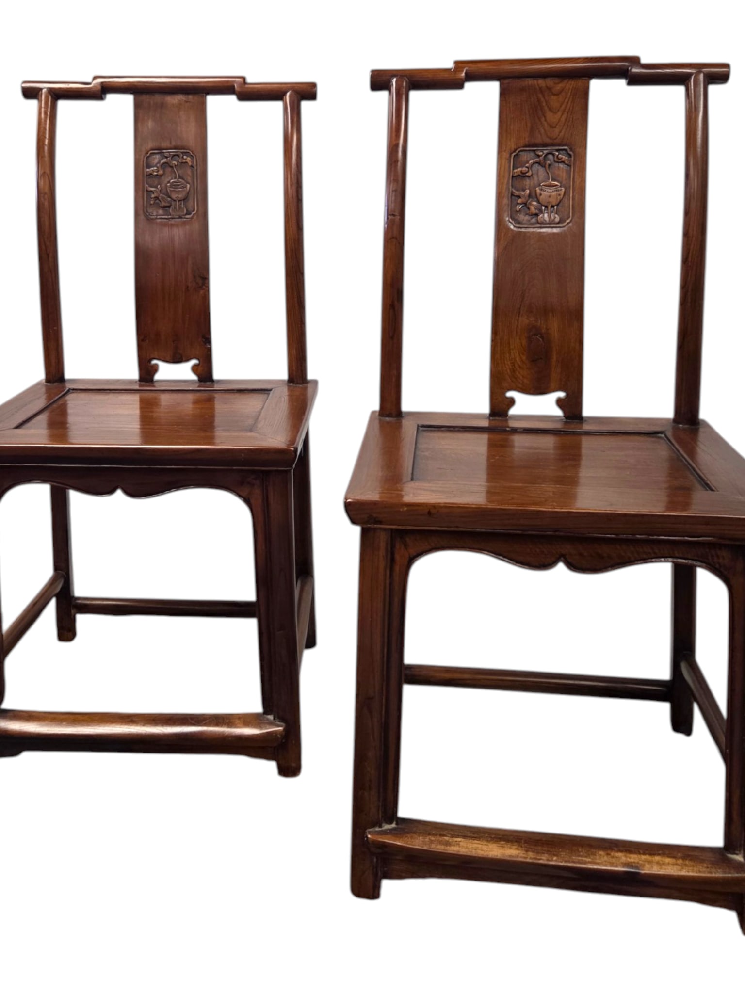 PAIR OF CARVED WOOD MING STYLE CHAIRS: Pair of carved rosewood Ming style chairs. Each features a single vertical wood panel down the center with a square hand carved medallion. The relief depicts tradional chinese motif such as a planted