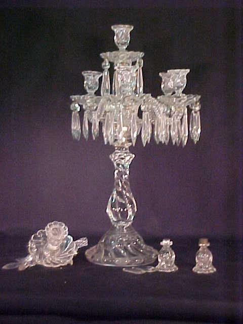 ANTIQUE CRYSTAL CANDELABRA LARGE: One arm has been broken off but is available for repair. The other arm has been repaired. There are two extra candle holders of which one is cracked. Measures 14 3/4" wide x 23" high.