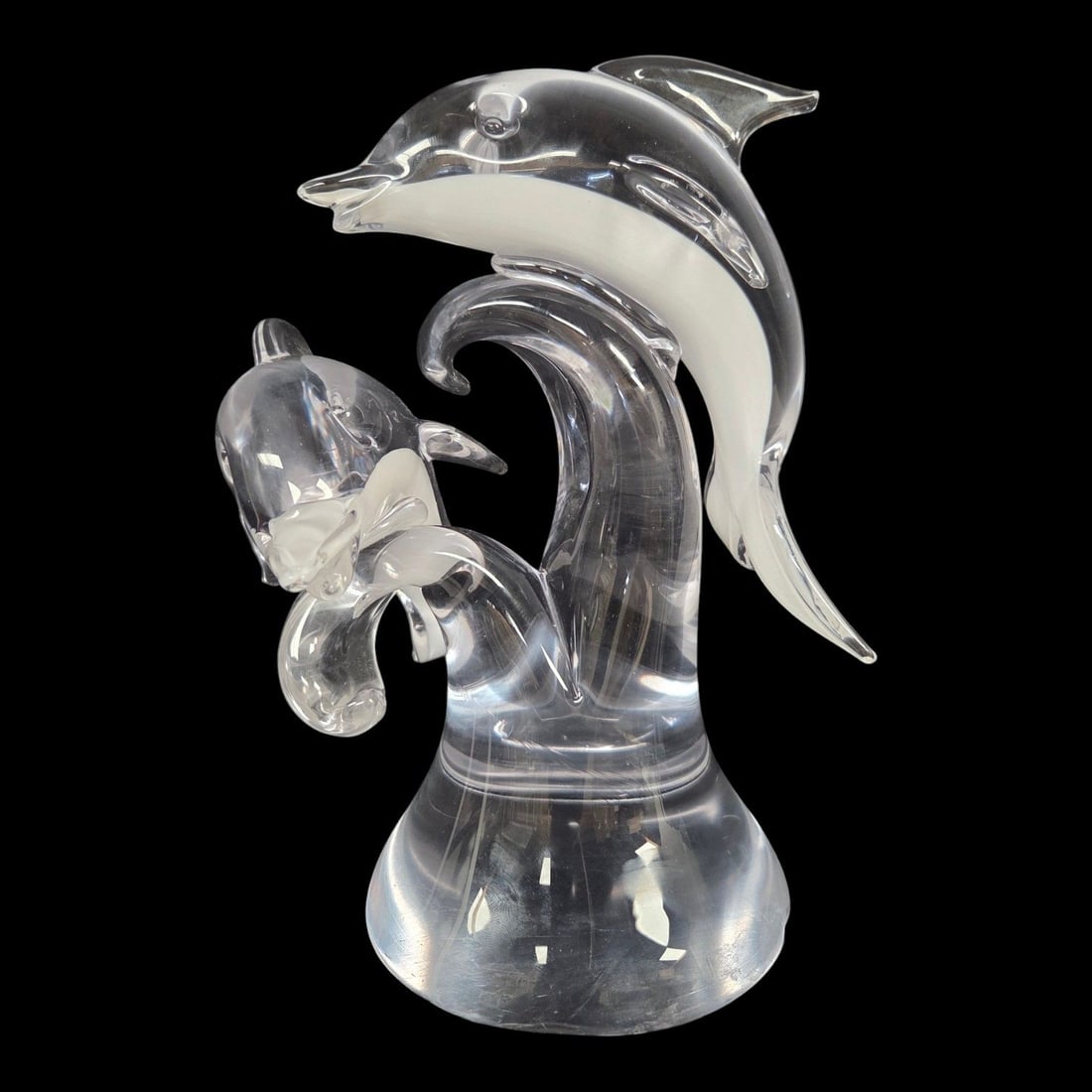 ART GLASS CRYSTAL DOLPHINS SCULPTURE: Art glass crystal sculpture capturing three dolphins gracefully leaping through clear ocean waves, offering an incredible light refraction from every angle. Signature (illegible) on bottom. Measures 1