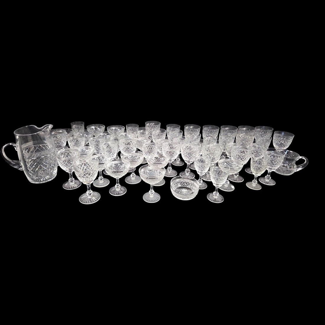 58 PIECE TUDOR CRYSTAL "HOLBEIN" STEMWARE GROUPING: 58 piece grouping of Tudor Holbein pattern cut crystal glass stemware, each featuring geometric and slanted line patterns and faceted bulge on the stem. Dimensions and piece count are as follows: 14 C